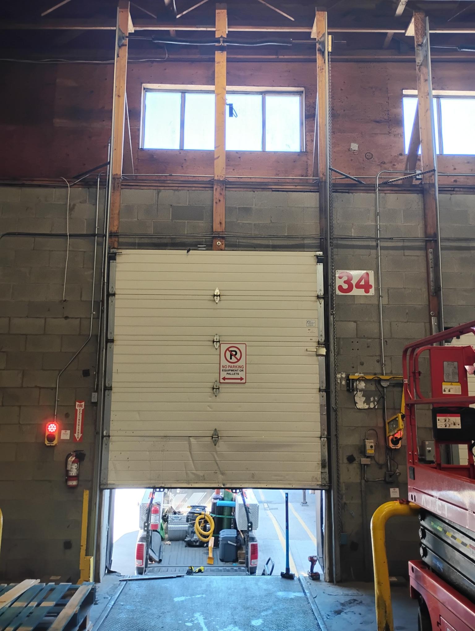 Overhead door bay interior with dock leveler and forklift