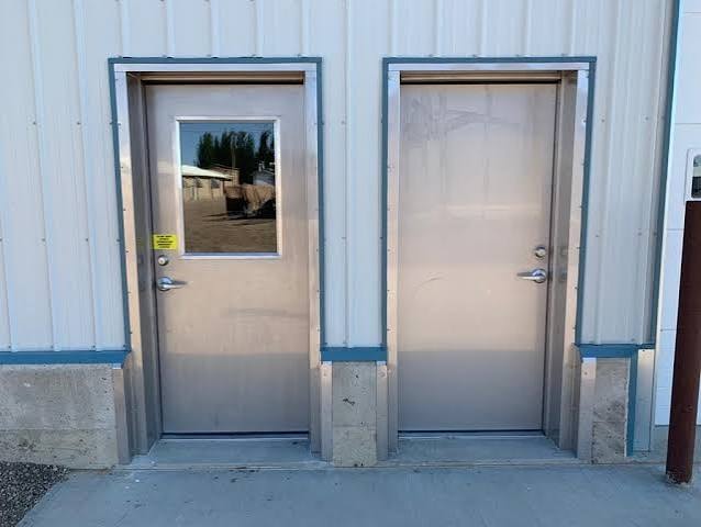 Two steel man doors with frames installed on industrial building exterior